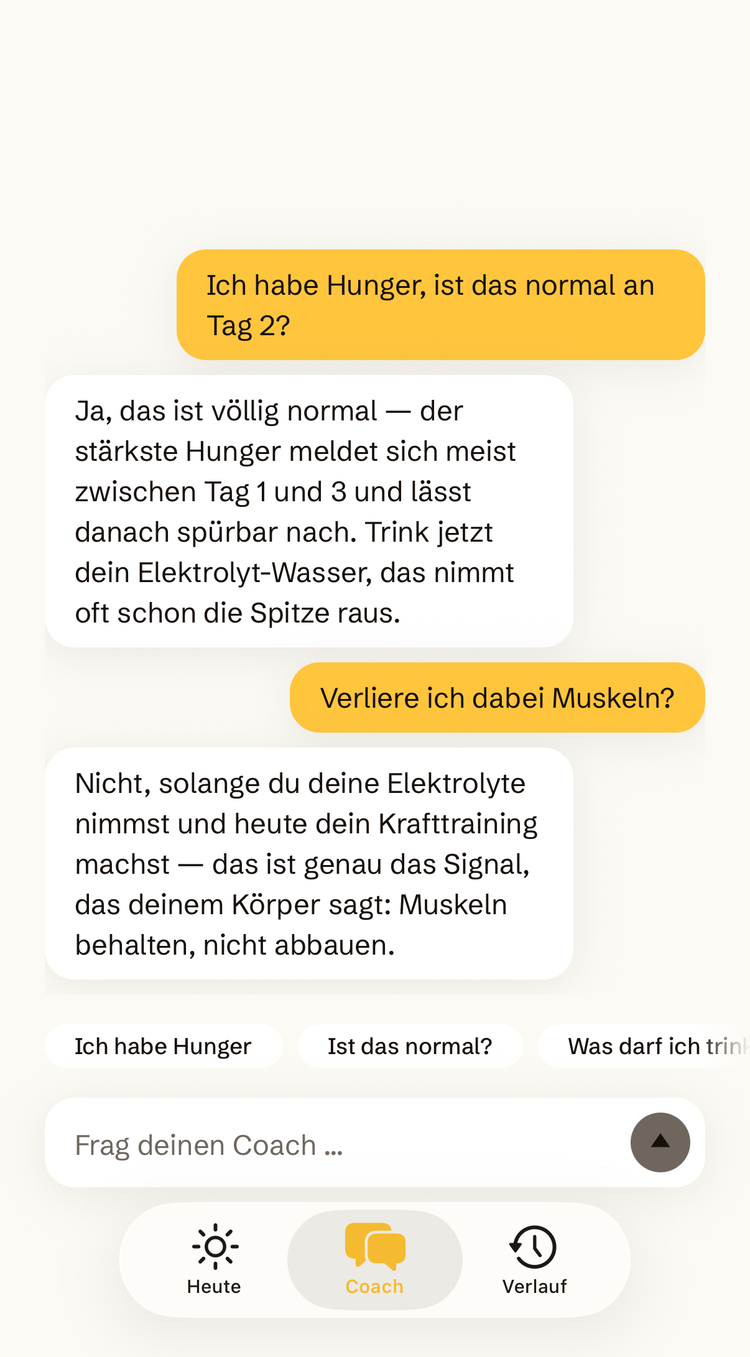 Coach-Screen der Solfasta-App: Auf „Ich habe Hunger, ist das normal an Tag 2?" antwortet der Coach beruhigend mit einem Elektrolyt-Tipp, auf „Verliere ich dabei Muskeln?" verweist er auf Elektrolyte und Krafttraining.